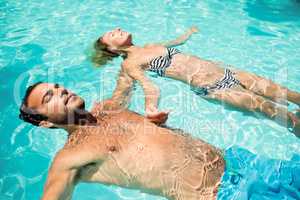 Peaceful couple floating in the pool