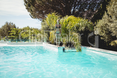 Fit woman standing on pools edge