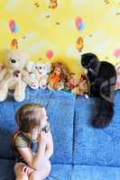 little girl looks at her cat in the children's room