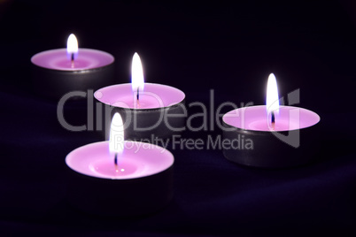 Beautiful violet candles in the darkness