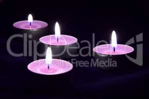 Beautiful violet candles in the darkness