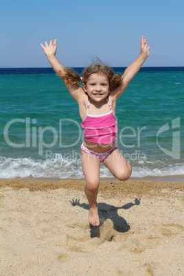 happy little girl jumping on the beach