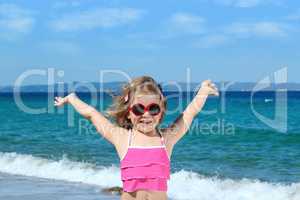 happy little girl with sunglasses on the beach