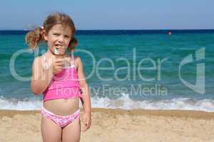 little girl eat ice cream on the beach