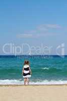 little girl looking boat at sea