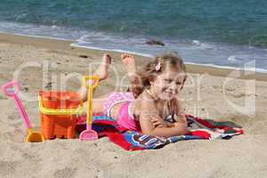 little girl lying on the beach