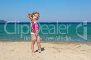 little girl with starfish and goggles on beach