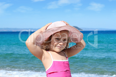 little girl with straw hat on beach