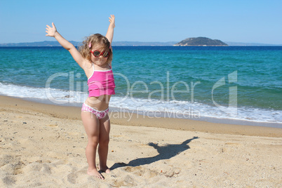 happy young girl with hands up on the beach