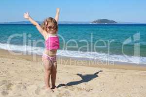 happy young girl with hands up on the beach