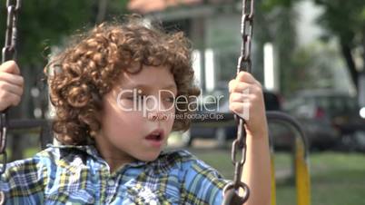 Boy Swinging on Swing Set