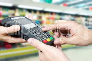 Hand with credit card swipe through terminal for sale in superma
