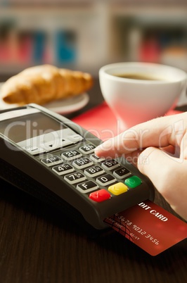 Man making payment with terminal for sale in cafeteria