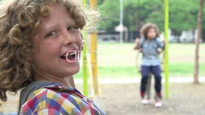 Brothers Having Fun on Swing Set