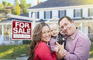 Young Family In Front of For Sale Sign and House