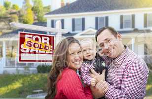 Young Family In Front of For Sale Sign and House
