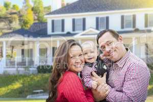 Young Family With Baby Outdoors In Front of Custom Home