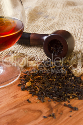 Glass of cognac and pipe with tobacco