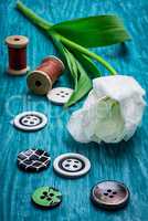 one white tulip and buttons with threads