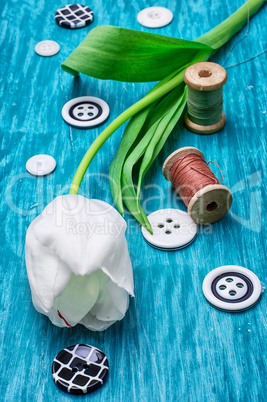 one white tulip and buttons with threads