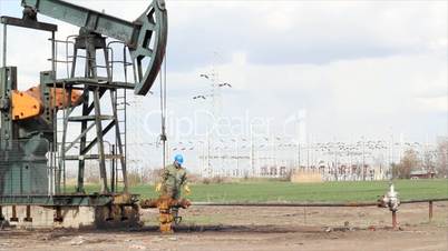 oil worker check pump jack and pipeline