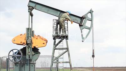 oil worker standing at the pump jack