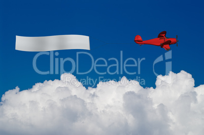 Red plane pulls blank banner above white clouds