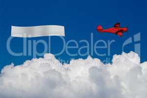 Red plane pulls blank banner above white clouds