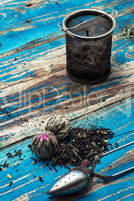 variety of dry tea leaves in jade stacks on wooden background