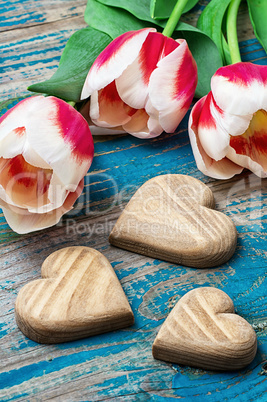 three hand-carved wooden heart with bouquet tulips