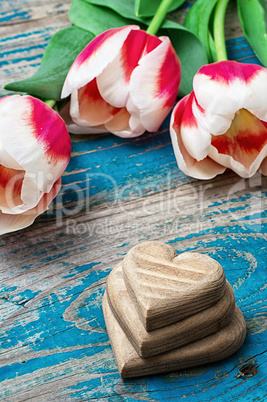 three hand-carved wooden heart with bouquet tulips