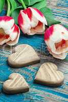 three hand-carved wooden heart with bouquet tulips