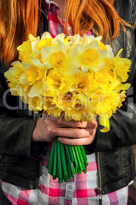 figure girl with bouquet of daffodils in his hands