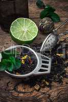 tea brew with lime and mint on wooden background