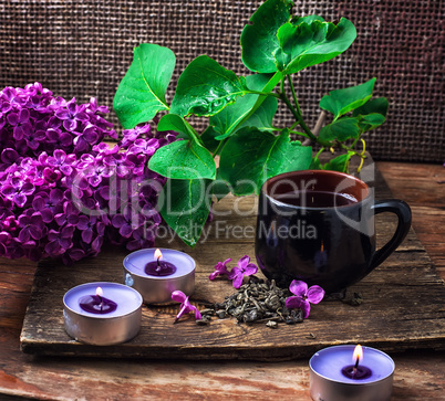 Cup of tea in composition with lilacs