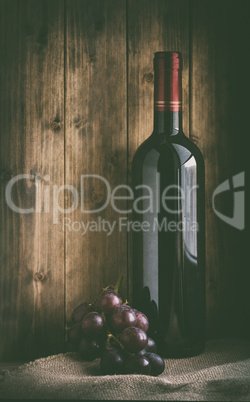 bottle of red wine with grapes