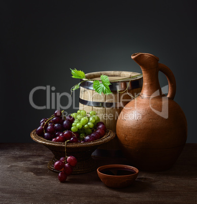 bowl with red wine pitcher with a barrel and grapes