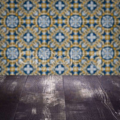 Wood table top and blur vintage ceramic tile pattern wall