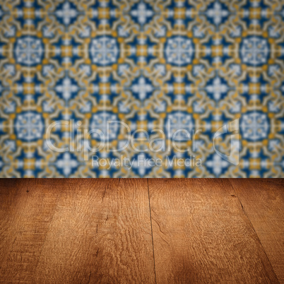 Wood table top and blur vintage ceramic tile pattern wall