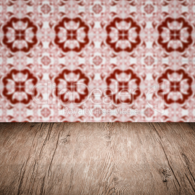 Wood table top and blur vintage ceramic tile pattern wall