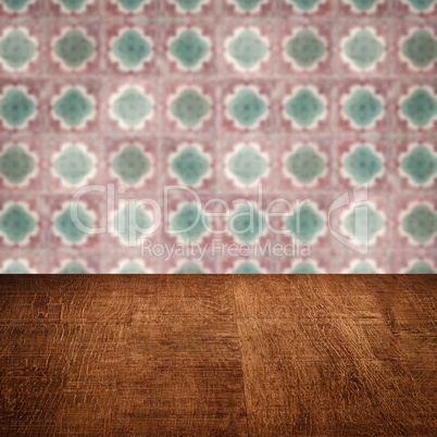 Wood table top and blur vintage ceramic tile pattern wall