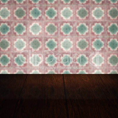 Wood table top and blur vintage ceramic tile pattern wall