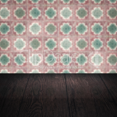 Wood table top and blur vintage ceramic tile pattern wall