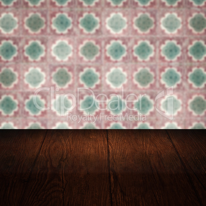 Wood table top and blur vintage ceramic tile pattern wall