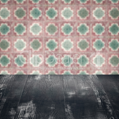 Wood table top and blur vintage ceramic tile pattern wall