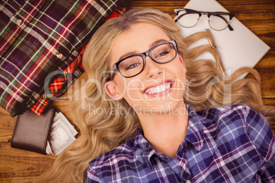 Composite image of a blonde hipster lying on the floor