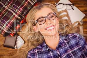 Composite image of a blonde hipster lying on the floor