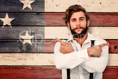 Composite image of confident hipster pointing sideways with arms