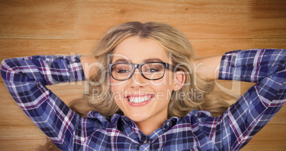 Composite image of a blonde hipster lying on the floor