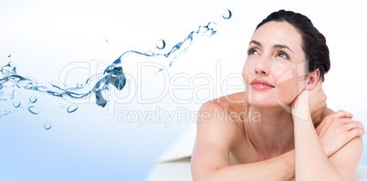 Composite image of smiling brunette relaxing on massage table
